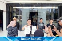 Ameng tunjukkan Tanda Bukti Lapor dan SP2HP terkait tindak pidana pengeroyokan kepada dirinya di restoran Hainan miliknya (Foto : Red)