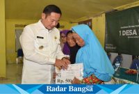 Bupati Lamongan Yuhronur Efendi saat menyerahkan bantuan sosial  (ist)