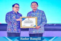 PJ Gubernur Jawa Timur, Adhy Karyono, menyerahkan lansung penghargaan  kepada Bupati Lamongan, Yuhronur Efendi, pada acara puncak peringatan Hari Keluarga Nasional ke-31 Provinsi Jawa Timur yang berlangsung di Jatim Expo Convention Exhibition Surabaya pada Rabu (10/7). (Dok Istimewa)