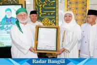 (Kanan) Syeikh Fadhil Bedah Tafsir Al Jailani dan (kiri)   Ketua Umum PP Muslimat NU, Khofifah Indar Parawansa saat menerima karya Syeikh Abdul Qadir Al Jailani di Masjid Nasional Al Akbar Surabaya, pada Jumat, (19/07/2024) (IST)