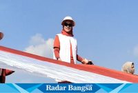 Kepala Disparbud Lamongan, Siti Rubikah,saat  ikut membentangkan bendera Merah Putih sepanjang 579 meter di Waduk Gondang Sugio Lamongan  pada Minggu (11/8). (IST)