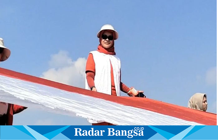 Kepala Disparbud Lamongan, Siti Rubikah,saat  ikut membentangkan bendera Merah Putih sepanjang 579 meter di Waduk Gondang Sugio Lamongan  pada Minggu (11/8). (IST)