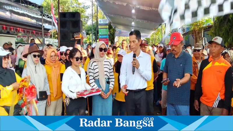 Kepala Desa Setro Ahmad Saiful didampingi Ketua panitia menggunting pita pertanda acara jalan sehat dimulai.