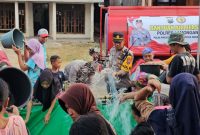 IPTU Tulus Haryanto, S.E., M.H., Kapolsek Tikung saat membagikan bantuan air bersih (IST)