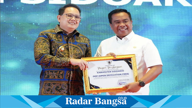 Pj  Gubernur Jawa Timur, Adhy Karyono, saat menyerahkan penghargaan  ODFkepada Pjs. Bupati Sidoarjo, Muhammad Isa Anshori, pada puncak acara Hari Kesehatan Nasional ke-60 di Hotel Aston (Foto Istimewa)