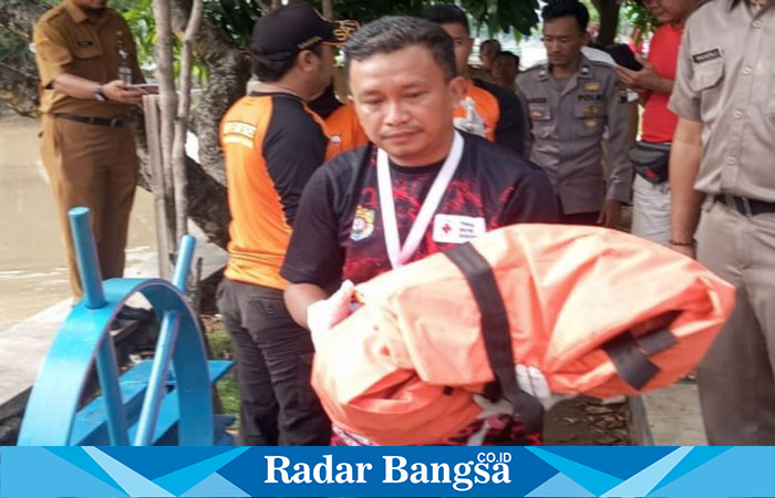 Petugas BPBD Kendal, sedang mengendong Jenazah  Bayi, usai ditemukan di Desa Sedayu. (RadarBangsa.co.id/Rob).