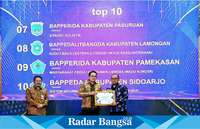 Pj Gubernur, Adhy Karyono, menyerahkan kepada Kepala Badan Perencanaan Pembangunan, Penelitian, dan Pengembangan Daerah Kabupaten Lamongan, Sujarwodi Mercure Surabaya Grand Mirama (IST)