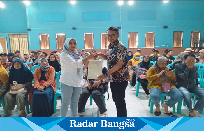 Kepala Desa Bulu Kerto Suhermawan menyerahkan Sertipikat tanah secara simbolis pada warga melalui PTSL (Dok foto RadarBangsa.co.id/Heru Is)