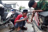 Servis sepeda motor sedang lakukan akibat terkena banjir.(RadarBangsa.co.id).