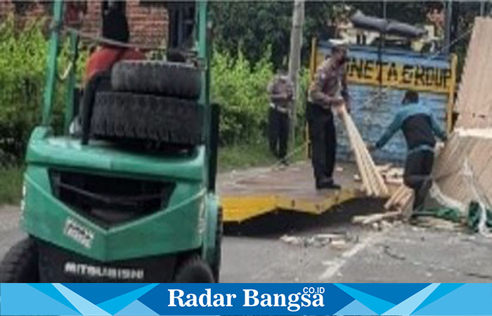 Kanit Lantas Polsek Driyorejo, Ipda Aang Sutikno, memimpin pengawasan evakuasi  di lokasi kejadian muatan yang beserakan (ist)