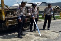 Kanit Kamsel, Ipda Muji Agung K., S.H.,  Satlantas Polres Lamongansaat  melakukan survei terkait kondisi jalan berlubang di Jembatan Pucangro, Jalan Raya Sukodadi-Paciran (ist)