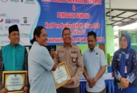 Camat Taman, Arie Prabowo, saat memberikan piagam kepada anggota PWI Sidoarjo (ist) 