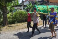 Bhabinkamtibmas Aipda M. Fathurozi saat mengantar jenazah mantan PHL Polsek Tikung, di Desa Bakalanpule, Lamongan ke pemakaman