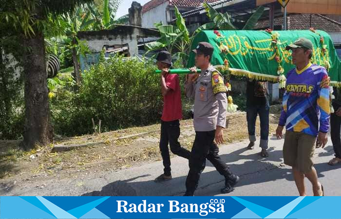 Bhabinkamtibmas Aipda M. Fathurozi saat mengantar jenazah mantan PHL Polsek Tikung, di Desa Bakalanpule, Lamongan ke pemakaman
