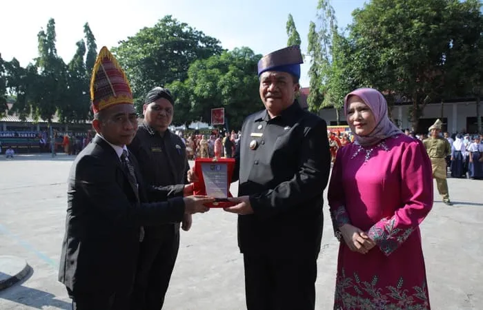 Plt Kadis Pendidikan Musa Al Bakri memberikan plakat penobatan 