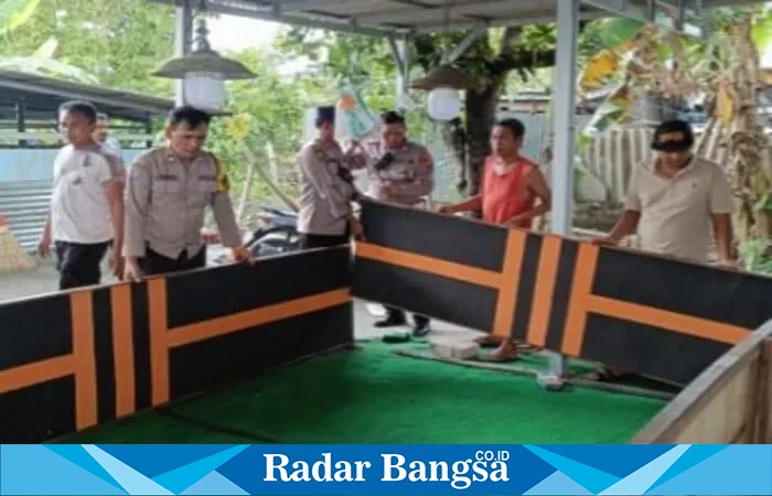 Petugas Polsek Lakarsantri mengamankan ayam dan sepeda motor saat penggerebekan arena judi sabung ayam di Made Sambikerep Surabaya.(Istimeaw)