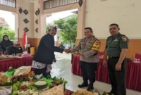 Kapolsek Tikung AKP Anang Purwo Widodo  saat potong tumpeng   pada Apel Hari Jadi Lamongan ke-456 di Pendopo Kecamatan Tikung, Senin (26/5/2025) (Dok Istimewa)