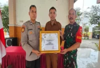 (kanan) Bhabinkamtibmas Aiptu Suwawi, (tengah) Kepala Desa Botoputih Rudi Santoso, dan (kiri) Babinsa Koptu Endro menunjukkan piagam penghargaan SIJALINMAJATARU yang diterima dari Gubernur Jawa Timur. (Dok Istimewa)
