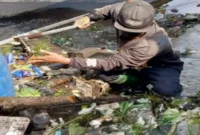 Petugas PUPR Kota Batu membersihkan sampah menumpuk di saluran drainase Jalan Giripurno (ist)