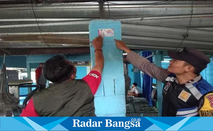 Anggota Polres Batu melakukan program maksimal memasang stiker Call Center 110 ke tiga wilayah Kecamatan di Kota Batu. Foto: Humas Polres Batu / RadarBangsa