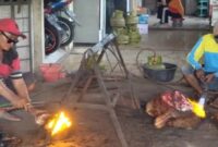 Kusnan, warga Tambakrigadung, Tikung, Lamongan, tengah membakar kepala sapi menggunakan alat las untuk melayani pelanggan saat Idul Adha, Minggu (8/6/2025). (Dok Ho/Radarbangsa)