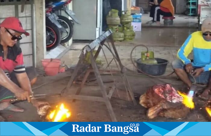 Kusnan, warga Tambakrigadung, Tikung, Lamongan, tengah membakar kepala sapi menggunakan alat las untuk melayani pelanggan saat Idul Adha, Minggu (8/6/2025). (Dok Ho/Radarbangsa)