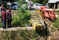 Personel Polsek Ngimbang melakukan pengamanan di lokasi jembatan rusak penghubung Ngimbang–Bluluk, Kamis (5/6/2025). Perbaikan awal dilakukan bersama Dinas PU Bina Marga Lamongan. | (Radarbangsa/Polsek Ngimbang)