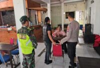 Petugas Polsek Tikung saat memberikan himbauan kepada pemilik warkop di jalur Mantup–Tikung, Selasa (8/7), menjelang malam pengesahan PSHT. (ist)