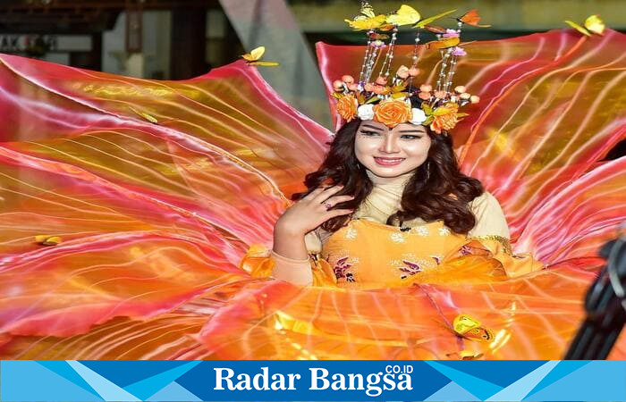 Busana bernuansa oranye dan hiasan kepala penuh bunga dan kupu-kupu, simbol semangat kreativitas dalam Sendangagung Batik Carnival 2025. (IST)