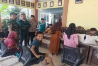 Bhabinkamtibmas Polsek Tikung Aiptu Suwawi bersama Babinsa dan perangkat desa mendampingi penyaluran bantuan beras cadangan pangan pemerintah kepada 194 KPM di Balai Desa Botoputih, Kecamatan Tikung, Lamongan, Minggu (27/7/2025). (Dok foto Ho/RadarBangsa)