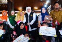 Gubernur Jawa Timur Khofifah Indar Parawansa saat menyerahkan bantuan sosial kepada warga Gresik di Pendopo Alun-Alun Gresik, Senin (28/7/2025). (Foto Dok Ho/RadarBangsa)