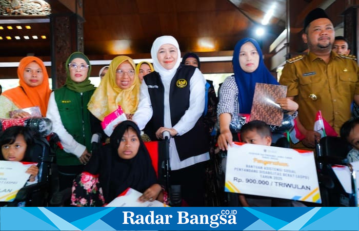 Gubernur Jawa Timur Khofifah Indar Parawansa saat menyerahkan bantuan sosial kepada warga Gresik di Pendopo Alun-Alun Gresik, Senin (28/7/2025). (Foto Dok Ho/RadarBangsa)