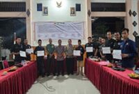 Para pimpinan perguruan silat se-Kecamatan Tikung bersama Forkopimcam Tikung menunjukkan surat pernyataan dukungan terhadap Maklumat Bersama Pengesahan PSHT, dalam Rakor Sosialisasi Maklumat Suro yang digelar di Pendopo Kecamatan Tikung, Kamis malam (3/7/2024).  | Dok Foto Ho/RadarBangsa