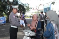 Petugas Satlantas Polres Lombok Tengah memberikan brosur imbauan tertib berlalu lintas kepada pengendara saat Operasi Patuh Rinjani 2025 di kawasan Kota Praya, Rabu (16/7/2025). | Foto Dok Ho/RadarBangsa