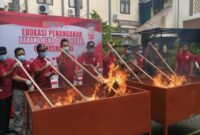 Ratusan ribu batang rokok ilegal dan puluhan botol miras tanpa izin dibakar hingga habis dalam pemusnahan barang bukti gabungan di Lamongan. (ist)