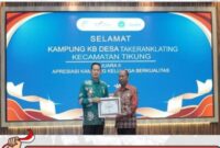 Bupati Lamongan H. Yuhronur Efendi menyerahkan penghargaan Kampung Keluarga Berkualitas kepada Kepala Desa Takeranklating, Yasmuin, dalam peringatan HARGANAS ke-32 di Alun-Alun Lamongan, Senin (31/07/2025). (Foto Dok Ho/RadarBangsa)