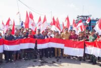Gubernur Jawa Timur Khofifah Indar Parawansa berfoto bersama nelayan, pejabat daerah, dan unsur Forkopimda sambil membentangkan bendera Merah Putih di Pelabuhan Tamperan, Pacitan, Selasa (12/8/2025), usai penyerahan bantuan untuk sektor perikanan (Foto Dok Ho/RadarBangsa)