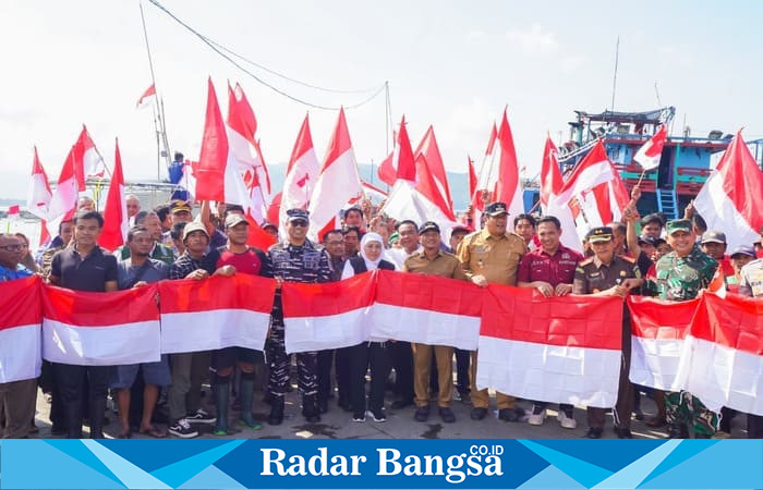Gubernur Jawa Timur Khofifah Indar Parawansa berfoto bersama nelayan, pejabat daerah, dan unsur Forkopimda sambil membentangkan bendera Merah Putih di Pelabuhan Tamperan, Pacitan, Selasa (12/8/2025), usai penyerahan bantuan untuk sektor perikanan (Foto Dok Ho/RadarBangsa)