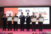 Bupati Lamongan Yuhronur Efendi menyerahkan penghargaan pada resepsi HUT ke-80 RI di Pendopo Lokatantra. (Foto Dok Ho/RadarBangsa.co.id)