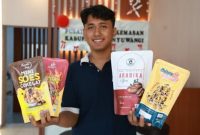 Seorang pelaku UMKM Banyuwangi menunjukkan produk kuliner dengan kemasan baru hasil fasilitasi Pusat Layanan Kemasan (PLK) Banyuwangi. Program ini digagas Pemkab Banyuwangi untuk meningkatkan daya saing produk lokal. (Dok. Pemkab Banyuwangi) 