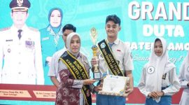 Bunda Genre Lamongan, Anis Kartika Yuhronur Efendi, menyerahkan trofi dan piagam penghargaan kepada Dimas Erlangga Putra Pratama yang terpilih sebagai Juara 1 Putra Duta Genre Lamongan 2025 pada grand final di Pendopo Lokatantra, Kamis (28/8/2025). (Foto Dok Ho/RadarBangsa.co.id)