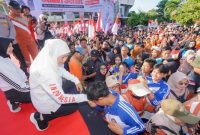 Gubernur Jawa Timur Khofifah Indar Parawansa bersalaman dengan peserta jalan sehat di GOR Joyoboyo, Kediri, Rabu (27/8/2025). Acara diikuti sekitar 21 ribu murid dan guru SMA/SMK/SLB se-Kediri dalam rangka HUT ke-80 RI. (Foto: Pemprov Jatim) 