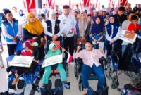 Gubernur Jawa Timur Khofifah Indar Parawansa menyerahkan bantuan sosial di Pendopo Trunojoyo Sampang, disertai pembagian bendera Merah Putih. (Foto Dok Ho/RadarBangsa.co.id)