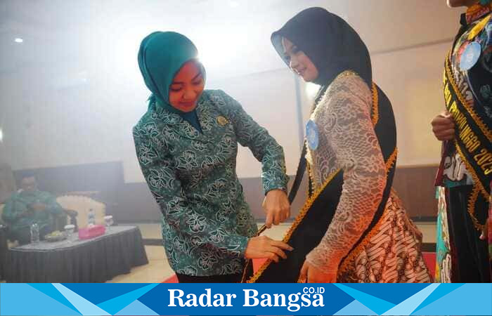 Ketua TP PKK Kota Probolinggo, dr. Evariani, menyematkan selempang kepada salah satu finalis Duta GenRe 2025 dalam Grand Final yang digelar di Gedung Puri Manggala Bhakti, Kamis (7/8/2025). (Foto Dok Ho/RadarBangsa)