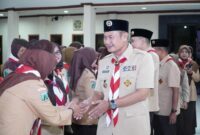 Ketua Majelis Pembimbing Cabang Gerakan Pramuka Lamongan, Yuhronur Efendi, berjabat tangan dengan anggota Pramuka usai kegiatan ulang janji di Pendopo Lokatantra, Rabu (13/8/2025) malam (Foto Dok Ho/RadarBangsa.co.id)