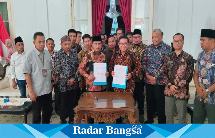 Bupati Bangkalan Lukman Hakim bersama Direktur Operasi PT Pupuk Indonesia, Dwi Satriyo Anurogo, menandatangani kesepakatan digitalisasi data petani di Pendopo Agung Bangkalan, Jumat (29/8/2025). (Foto Dok Ho/RadarBangsa.co.id)