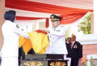 Bupati Lamongan Yuhronur Efendi menyerahkan Sang Merah Putih kepada Pasukan Paskibraka dalam upacara peringatan HUT ke-80 RI di Alun-Alun Lamongan, Minggu (17/8). (Foto Dok Ho/RadarBangsa.co.id)