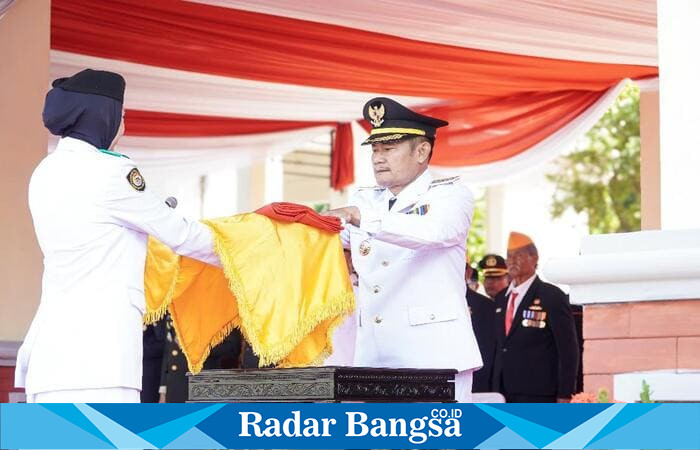 Bupati Lamongan Yuhronur Efendi menyerahkan Sang Merah Putih kepada Pasukan Paskibraka dalam upacara peringatan HUT ke-80 RI di Alun-Alun Lamongan, Minggu (17/8). (Foto Dok Ho/RadarBangsa.co.id)