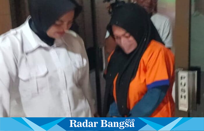 Tersangka kasus arisan bodong berinisial ENZ (27), warga Kecamatan Solokuro, saat digelandang petugas Polres Lamongan menggunakan baju tahanan berwarna oranye. (Foto Dok Ho/RadarBangsa.co.id)