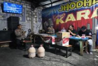 Petugas Polsek Sukodadi melakukan pendataan dan penyitaan minuman keras berbagai jenis saat razia di salah satu kafe wilayah Sukodadi, Lamongan, Sabtu malam (9/8/2025). (Foto Dok Ho/RadarBangsa.co.id)